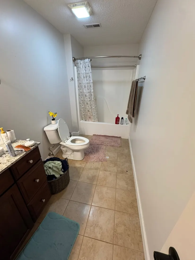Bathroom before Frontline Bathroom Project 2 with original tub, flooring, and vanity