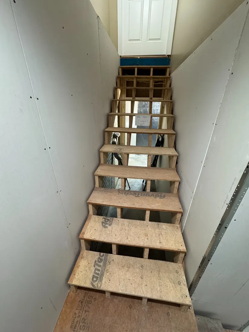 Commercial stairwell during drywall installation by Frontline Home Solutions