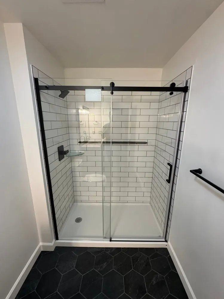 Completed black-framed glass shower with white subway tile in Frontline Bathroom Project 2