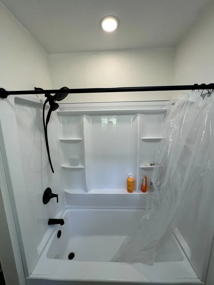 Completed white tub and shower surround in Frontline Bathroom Project 1