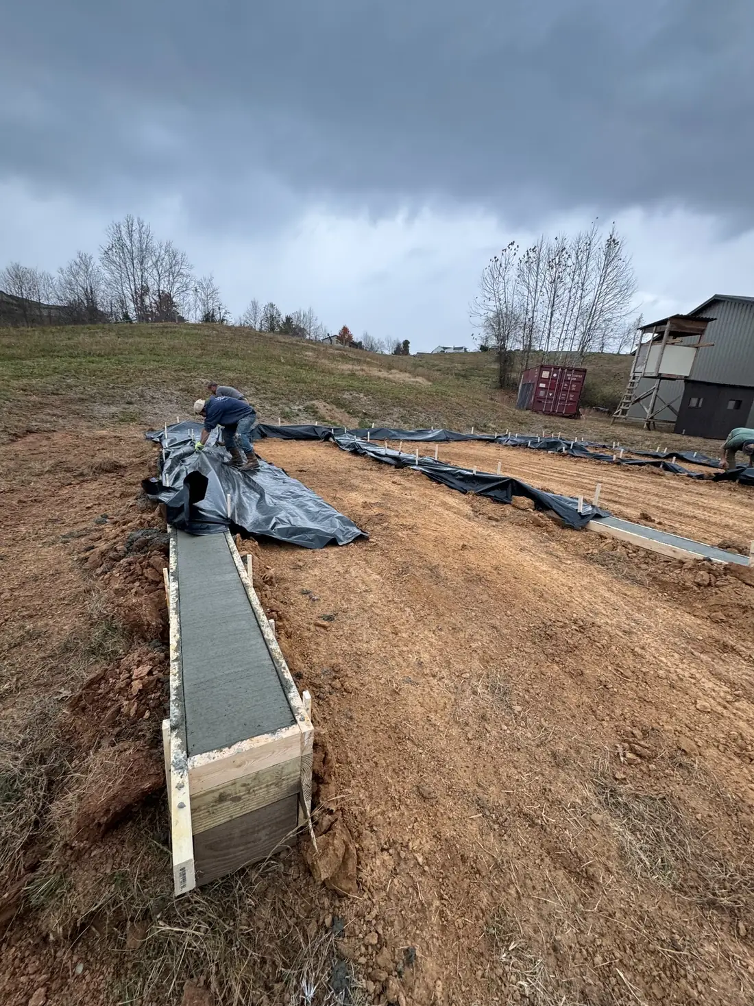 Fresh concrete footer installed for the steel-building support system